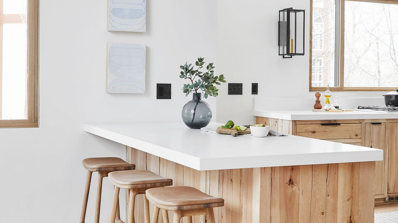 A Scandinavian-style home by Emily Henderson featuring beechwood cabinets topped with Cambria Quartz White Cliff countertops and matte black accents.