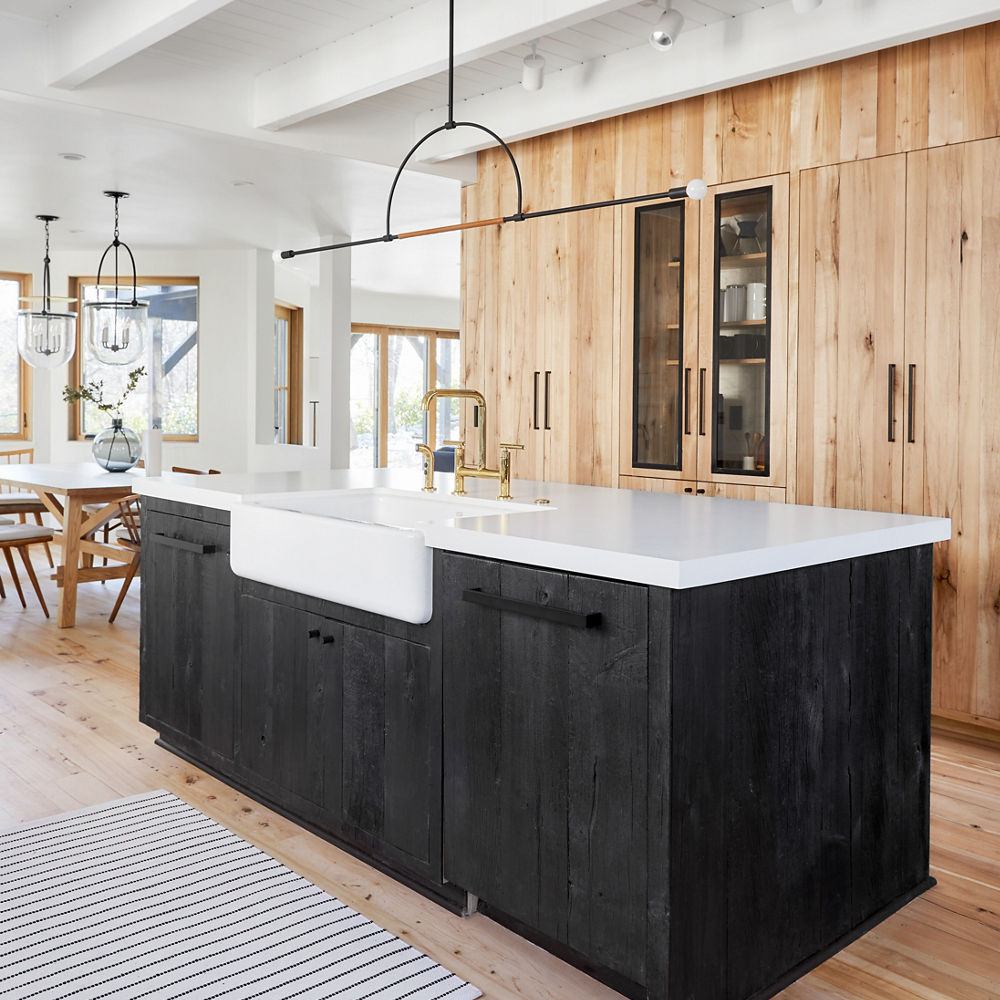 Mixed kitchen featuring an island with black wooden cabinets and White Cliff Matte quartz countertops.