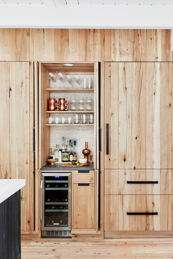A kitchen with various closed wooden doors and cabinets, creating a condensed kitchen area.