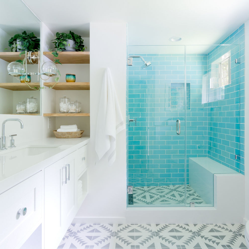A bright, white bathroom with a counter and siding with Cambria Whitehall quartz.