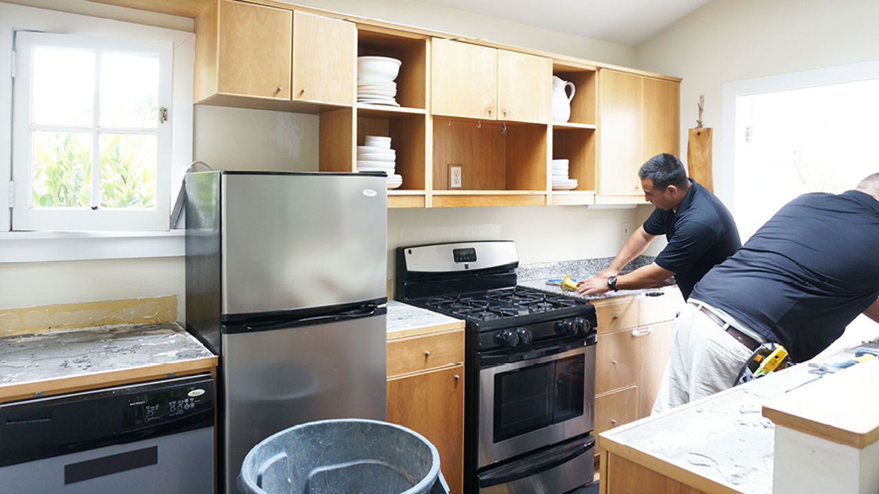 Installers removing granite countertops in Whitney's kitchen.