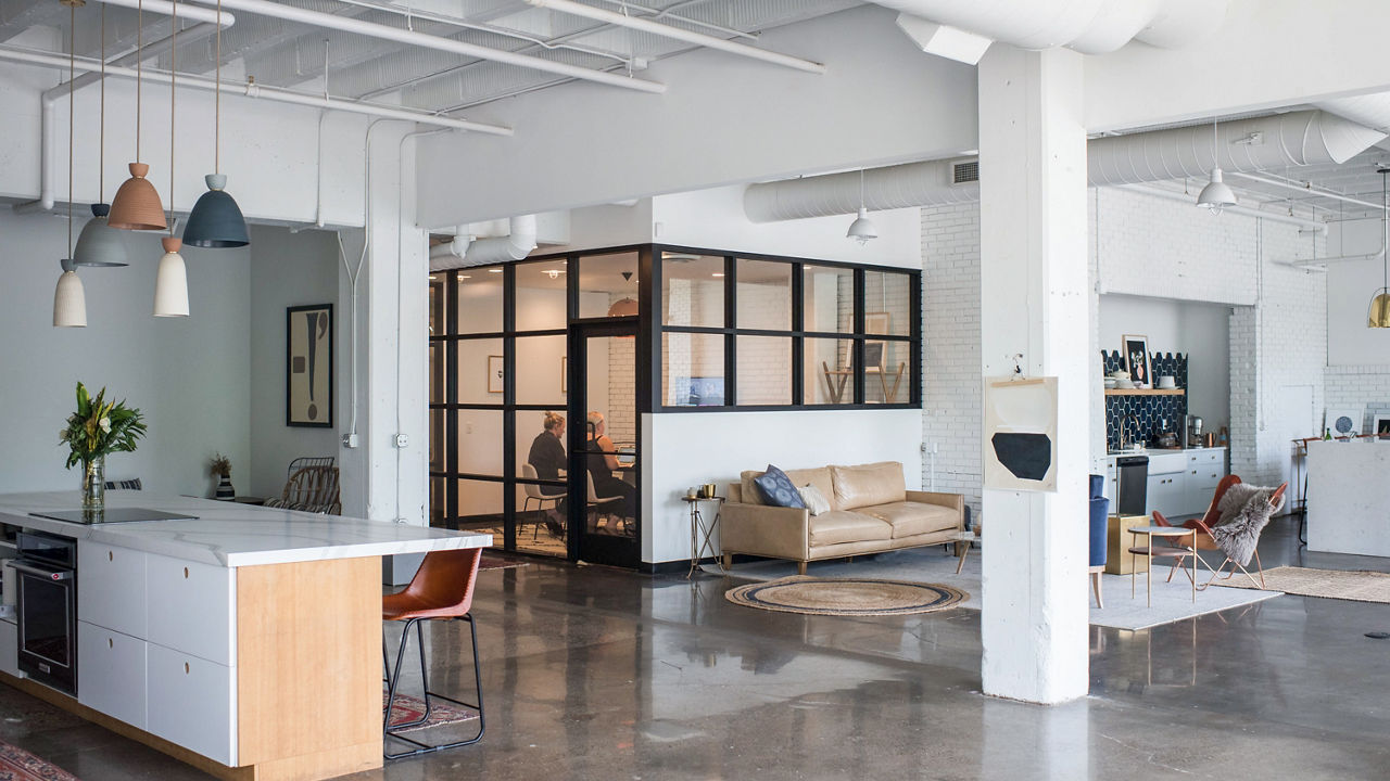 a workspace featuring a seating area, kitchen, and conference room.