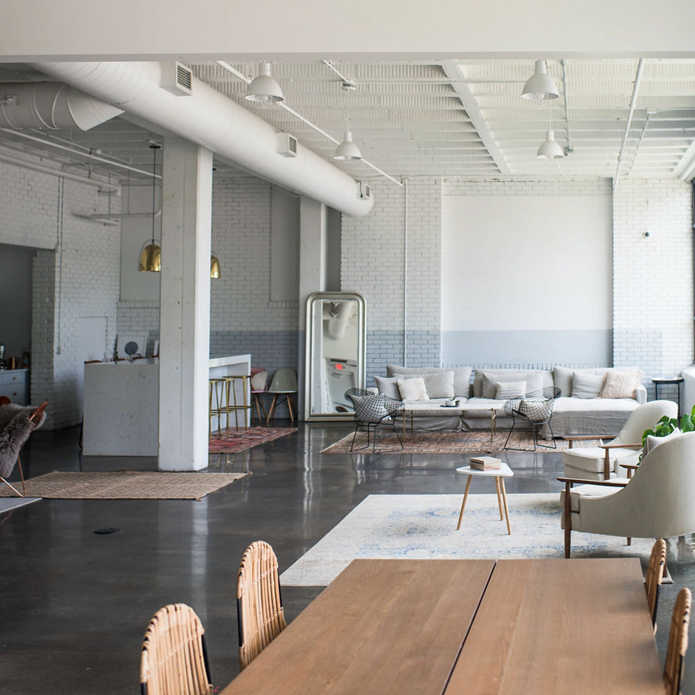 an industrial workspace with two seating areas, a kitchen, and a dining area. 